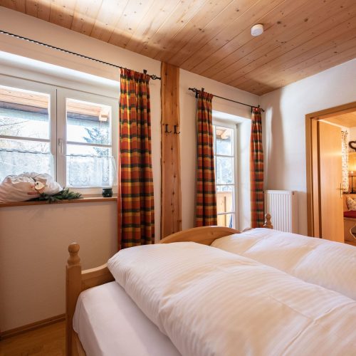 Doppelbett und Fenster in Ferienwohnung in Garmisch-Partenkirchen