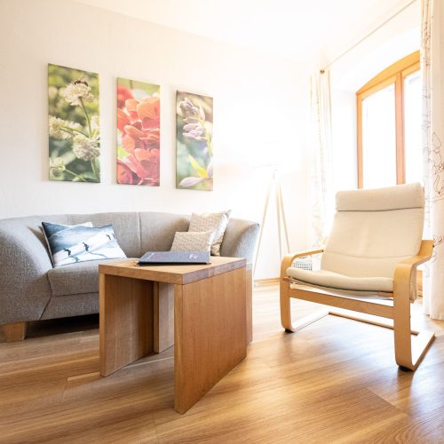 Wohnzimmer mit kleinem Sofa und Stuhl in Ferienwohnung in Garmisch-Partenkirchen
