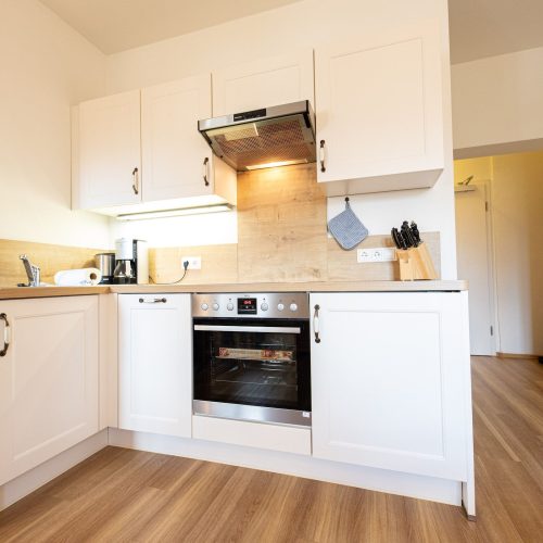 Küche in weiß mit Holz Arbeitsplatte in Ferienwohnung in Garmisch-Partenkirchen