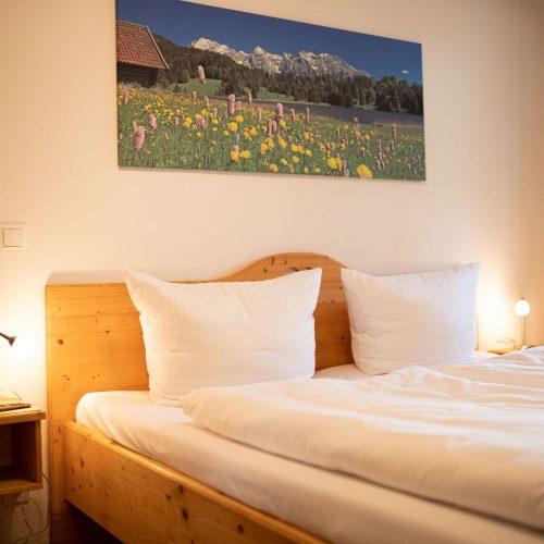 Doppelbett mit Nachttisch in Ferienwohnung in Garmisch-Partenkirchen