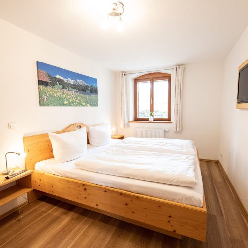 Doppelbett mit Holz Nachttisch in Ferienwohnung in Garmisch-Partenkirchen