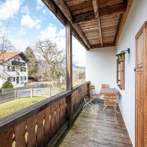 Balkon mit Stühlen und einem kleinen Tisch in Ferienwohnung in Garmisch-Partenkirchen