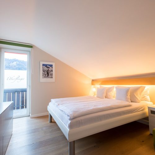 Schlafzimmer mit Bett und Ski Bildern in Ferienwohnung in Garmisch-Partenkirchen