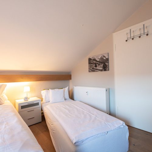 zwei Einzelbetten und Nachtschrank in Ferienwohnung in Garmisch-Partenkirchen