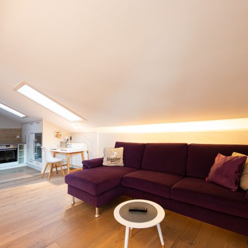 Wohnbereich mit violettem Sofa in Ferienwohnung in Garmisch-Partenkirchen