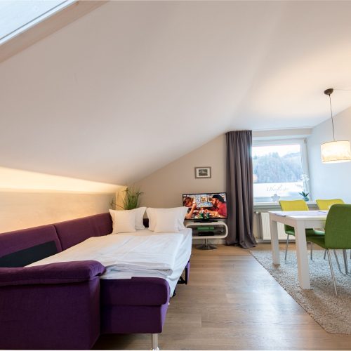 Schlafsofa in Lila und Essbereich in Ferienwohnung in Garmisch-Partenkirchen
