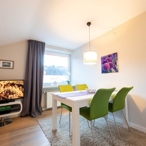 Essbereich mit Fernseher und Blumenbild in Ferienwohnung in Garmisch-Partenkirchen