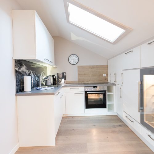 Küche in weiß mit Schränken in Ferienwohnung in Garmisch-Partenkirchen