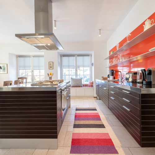 Küche mit einem gestreiften Teppich und silberner Arbeitsfläche in Ferienwohnung in Garmisch-Partenkirchen