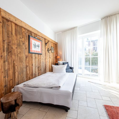 Schlafsofa und weiße Vorhänge in Ferienwohnung in Garmisch-Partenkirchen