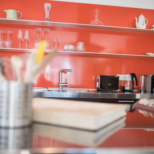 rote Küche mit verschiedenen Küchengeräten und Ablageplätze in Ferienwohnung in Garmisch-Partenkirchen