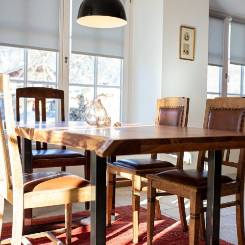 Essbereich mit gepolsterten Holzstühlen und einer schwarzen Hängelampe in Ferienwohnung in Garmisch-Partenkirchen