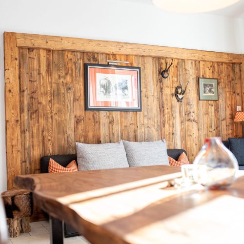 Holzwand mit Bildern und kleines dunkel graues Sofa in Ferienwohnung in Garmisch-Partenkirchen