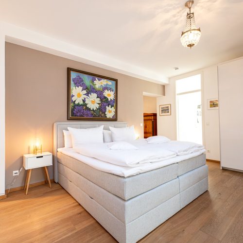 Schlafzimmer mit weißem großem Kleiderschrank und Doppelbett in Ferienwohnung in Garmisch-Partenkirchen