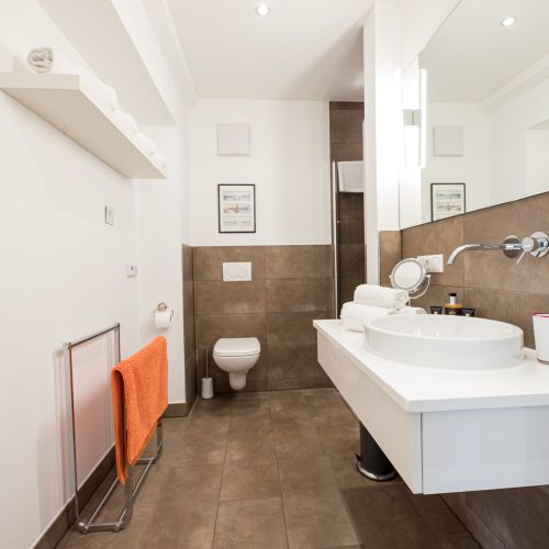 dunkle Fliesen und großer Spiegel im Badezimmer in Ferienwohnung in Garmisch-Partenkirchen