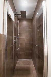 große Dusche mit dunklen Fliesen und Regendusche in Ferienwohnung in Garmisch-Partenkirchen