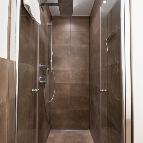 große Dusche mit dunklen Fliesen und Regendusche in Ferienwohnung in Garmisch-Partenkirchen