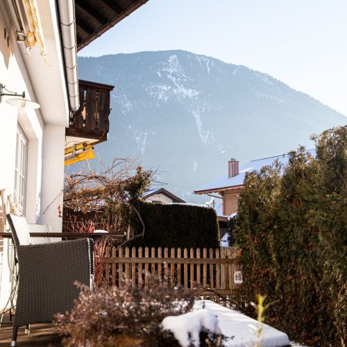 Terrasse mit zwei Stühlen und einem kleinen Tisch in Ferienwohnung in Garmisch-Partenkirchen