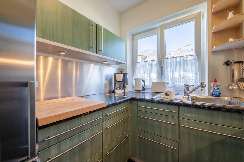 grüne Küche mit Spülbecken in Ferienwohnung in Garmisch-Partenkirchen