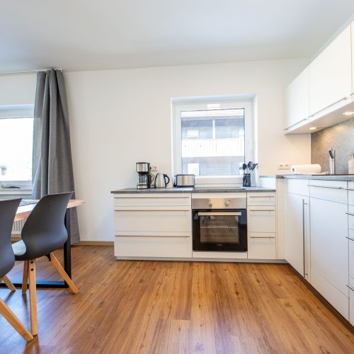 Küche mit Backofen und Fenstern in Ferienwohnung in Garmisch-Partenkirchen