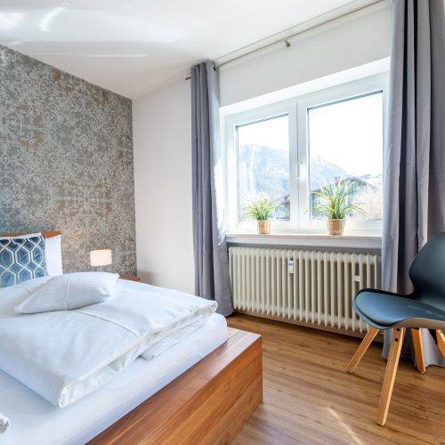 Schlafbereich mit einer Sitzmöglichkeit in Ferienwohnung in Garmisch-Partenkirchen