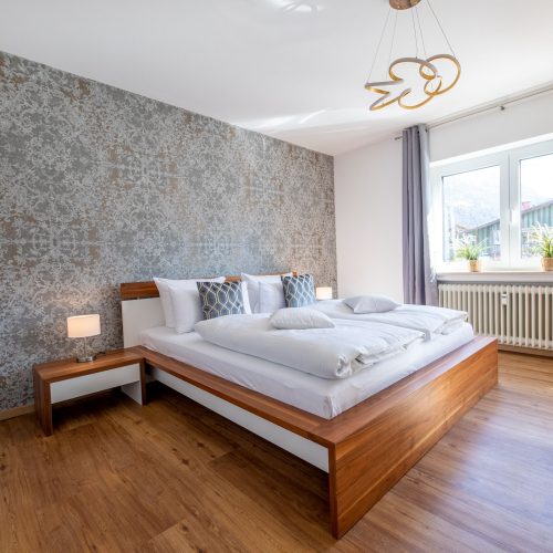 Schlafzimmer mit Nachttischen und Lampen in Ferienwohnung in Garmisch-Partenkirchen