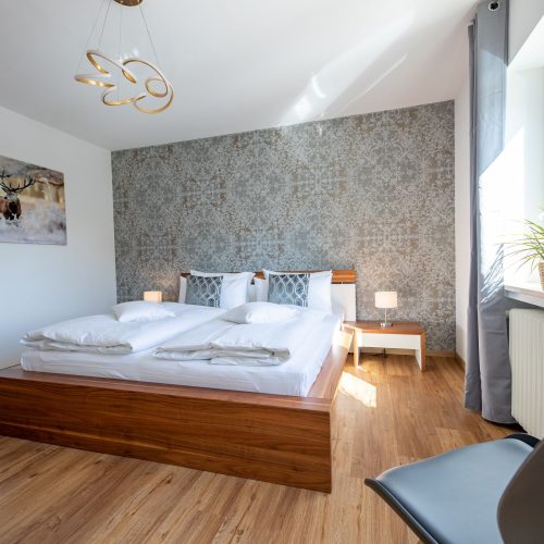 Schlafzimmer mit einem Doppelbett mit Holzrahmen in Ferienwohnung in Garmisch-Partenkirchen