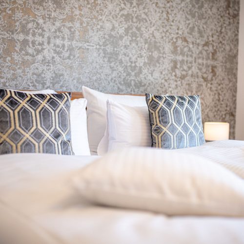 Schlafzimmer mit einer grauen, gemusterten Tapete