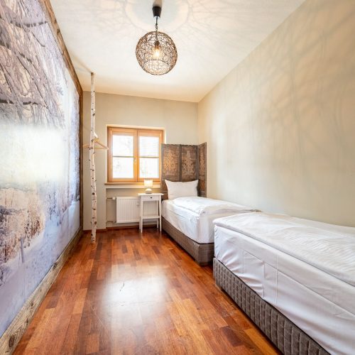 Schlafzimmer mit zwei Einzelbetten und einer Deckenlampe in Ferienwohnung in Garmisch-Partenkirchen