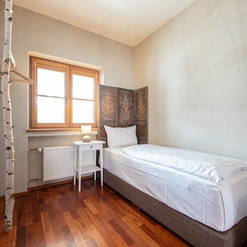 Schlafzimmer mit einem Einzelbett und einem Fenster in Ferienwohnung in Garmisch-Partenkirchen