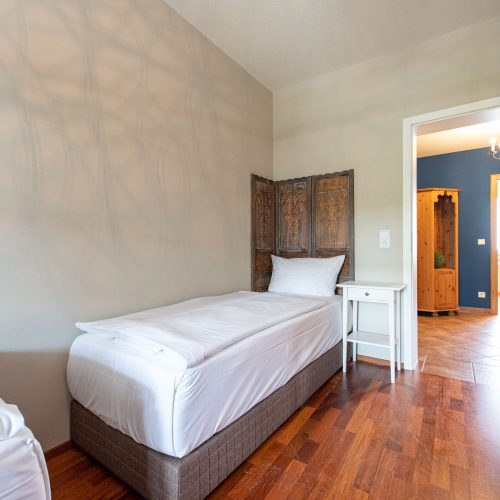 Schlafzimmer mit zwei einzelbetten und beiger Wand in Ferienwohnung in Garmisch-Partenkirchen