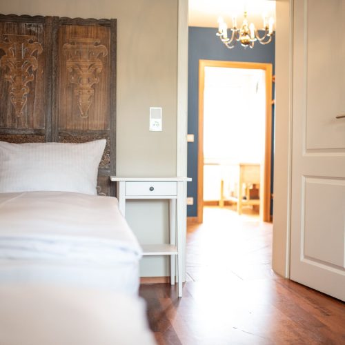 Schlafzimmer mit einem Einzelbett und einer gemusterten Tapete in Ferienwohnung in Garmisch-Partenkirchen