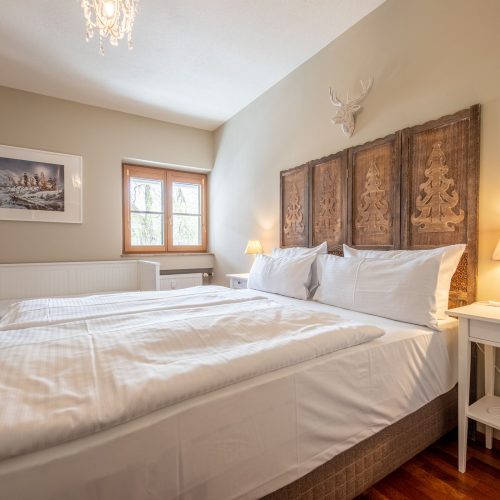 Schlafzimmer mit einem Doppelbett und einem Einzelbett in Ferienwohnung in Garmisch-Partenkirchen