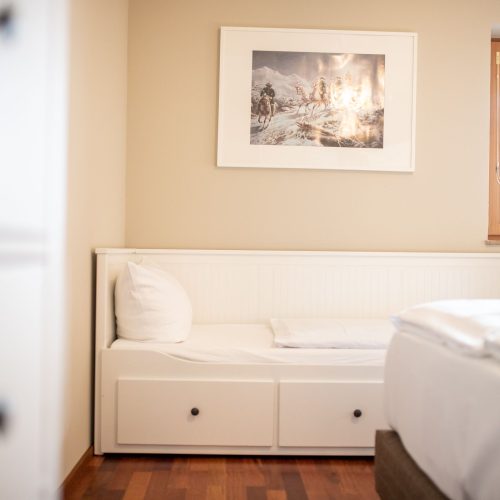 Schlafzimmer mit einem Einzelbett in weiß in Ferienwohnung in Garmisch-Partenkirchen