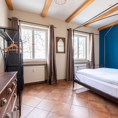 Schlafzimmer mit Fliesen und blauer Wand in Ferienwohnung in Garmisch-Partenkirchen