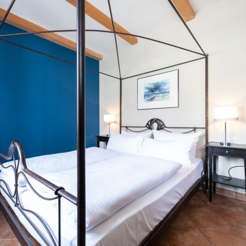 Schlafzimmer mit einem Doppelbett und schwarzen Nachttischen in Ferienwohnung in Garmisch-Partenkirchen