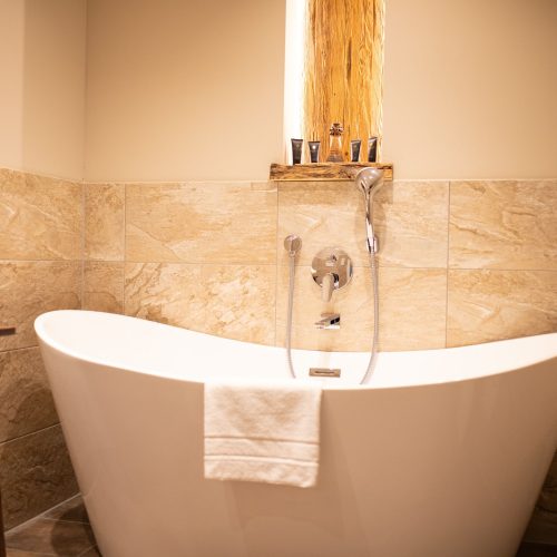 Badezimmer mit einer weißen Badewanne in Ferienwohnung in Garmisch-Partenkirchen