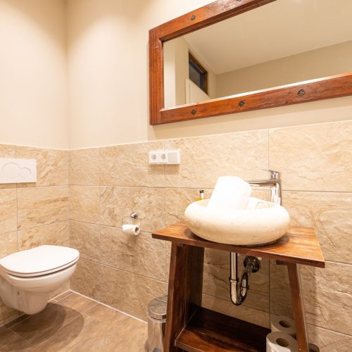 Badezimmer mit Sand farbenen Fliesen in Ferienwohnung in Garmisch-Partenkirchen