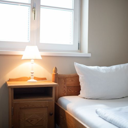 Bett mit Nachttisch und Lampe in Ferienwohnung in Garmisch-Partenkirchen