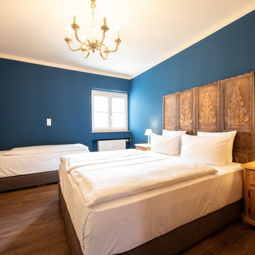 Schlafzimmer mit blauen Wänden und zwei Betten in Ferienwohnung in Garmisch-Partenkirchen