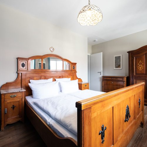 Bett mit Holzrahmen in Ferienwohnung in Garmisch-Partenkirchen