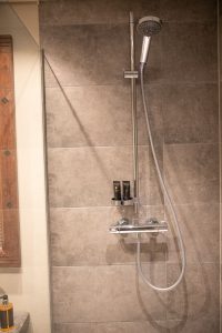Dusche mit dunklen Fliesen  in Ferienwohnung in Garmisch-Partenkirchen