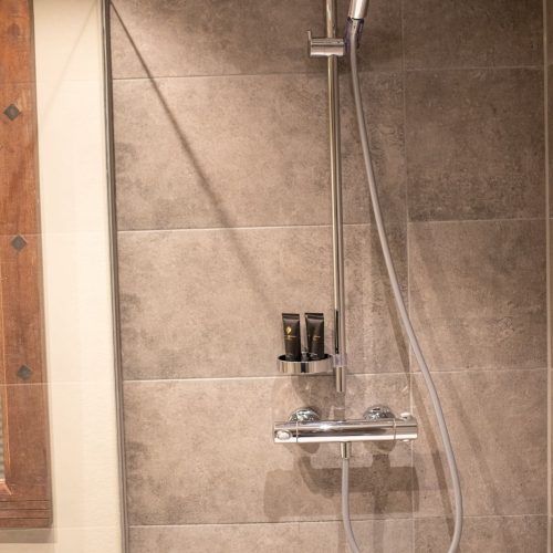 Dusche mit dunklen Fliesen in Ferienwohnung in Garmisch-Partenkirchen