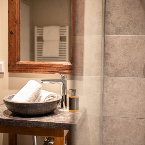 Badezimmer mit einem Spiegel mit braunem Rahmen in Ferienwohnung in Garmisch-Partenkirchen