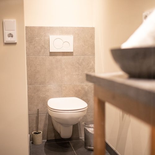 Badezimmer mit grauen Fliesen in Ferienwohnung in Garmisch-Partenkirchen