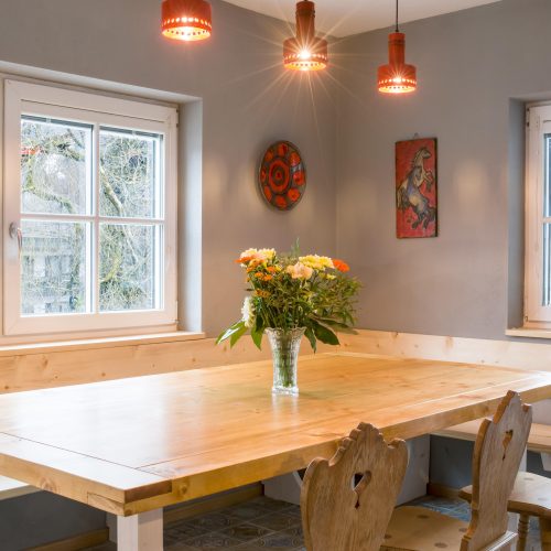 Esstisch mit Blumen und einer Sitzbank in Ferienwohnung in Garmisch-Partenkirchen