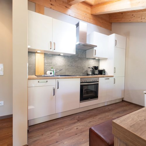 weiße Küche mit Herd und Ofen in Ferienwohnung in Garmisch-Partenkirchen