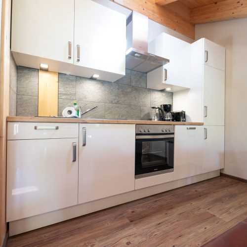 Küchenzeile mit weißen Schränken in Ferienwohnung in Garmisch-Partenkirchen