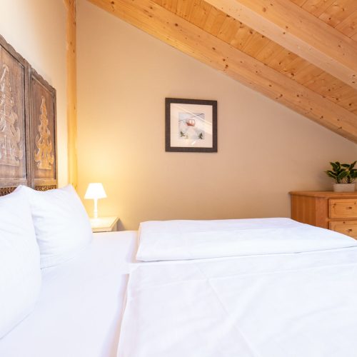 Doppelbett mit einer Schräge in Ferienwohnung in Garmisch-Partenkirchen