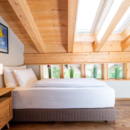 Einzelbett mit vielen kleinen Fenstern und Dachfenster in Ferienwohnung in Garmisch-Partenkirchen